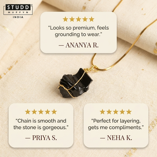 Flat-lay of the obsidian necklace with three five-star customer review cards