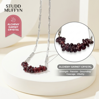 Alchemy Garnet Rice Chain Necklace draped over a white pedestal with a Garnet crystal zoom callout