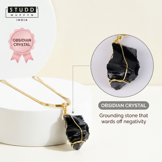 Black obsidian pendant on gold-tone Veloré snake chain draped over a white pedestal with an Obsidian crystal zoom callout