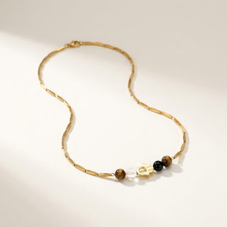 Green Harmony golden rice chain necklace with green aventurine, black obsidian and clear quartz beads on a soft cream backdrop
