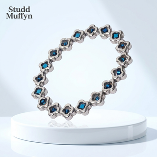Silver and blue clover bead bracelet displayed on a bright premium set