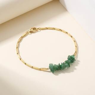 Green Aventurine crystal rice chain bracelet in gold tone laid flat on a soft cream surface