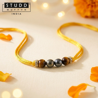 Unstoppable Rakhi with stone beads laid on cream silk with marigold petals