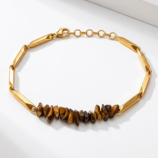 Tiger Eye crystal rice chain bracelet in golden links laid flat on a bright premium background