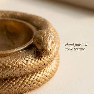 Close-up of the serpent head and detailed scale texture on the golden bowl