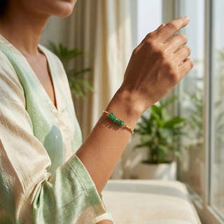 Woman's wrist wearing the Green Aventurine gold rice chain bracelet with a pastel outfit