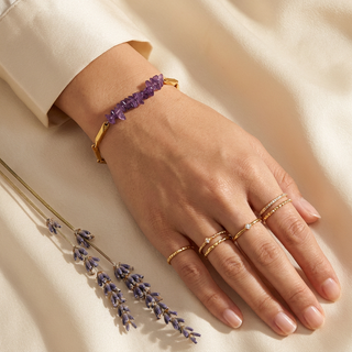 Amethyst bracelet styled with minimal gold rings on a woman's hand