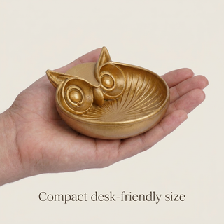 Golden owl money bowl held in a hand to show its compact size
