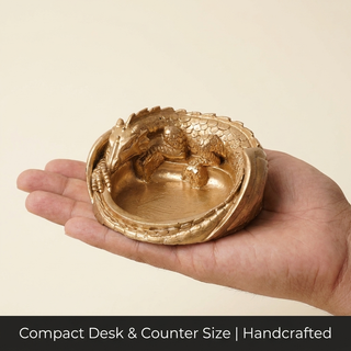 Dragon money bowl shown in hand to convey its compact desktop size